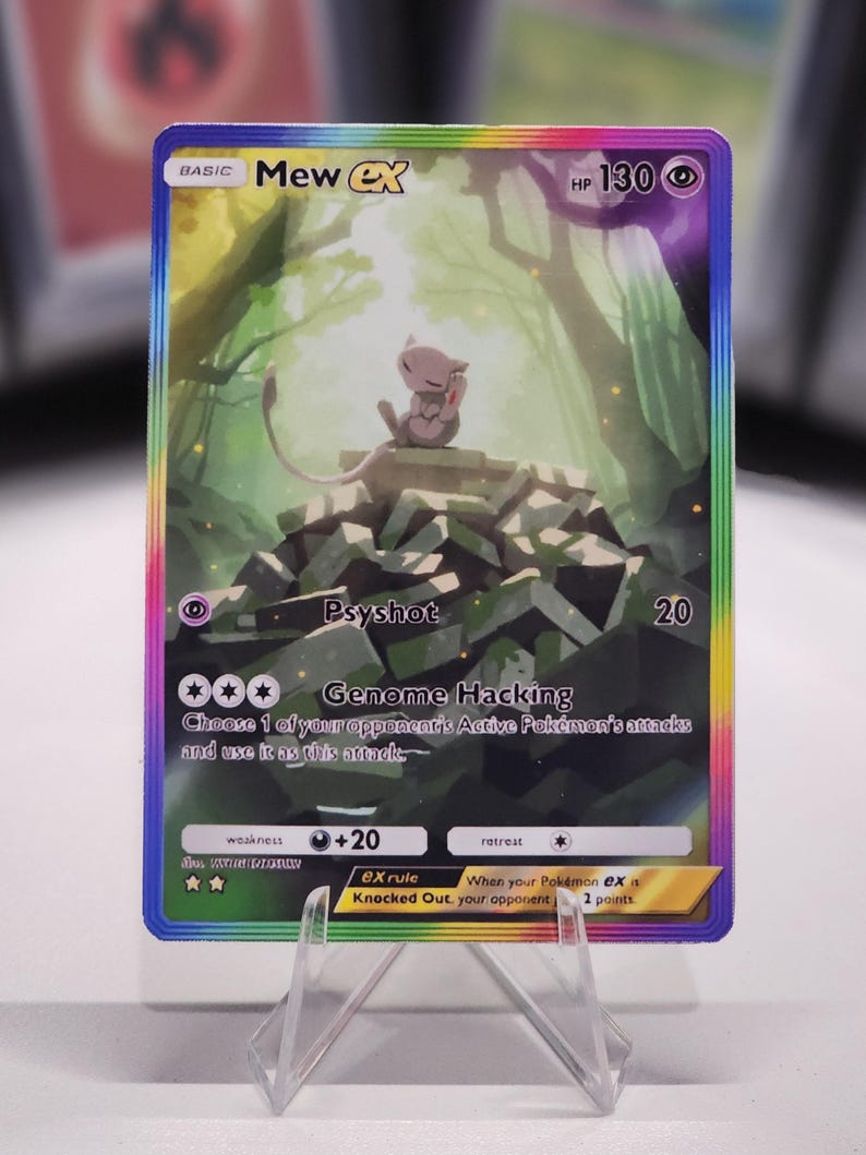 May include: A Pokemon trading card featuring Mew EX, a pink and white mythical Pokemon. The card has a rainbow border and a green and white background. The card's text reads "BASIC Mew EX HP 130 Psyshot 20 *** Genome Hacking Choose 1 of your opponent's Active Pokemon's attacks and use it as this attack weakness +20 retreat ex rule When your Pokemon ex is Knocked Out, your opponent takes 2 prize cards."
