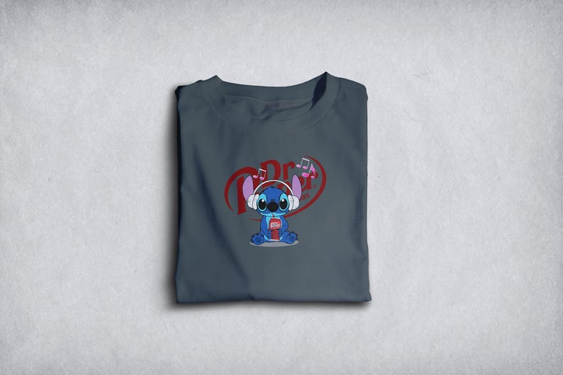 Może przedstawiać: Złożona, ciemnoszara koszulka z nadrukiem kresk&oacute;wki Stitcha w słuchawkach i trzymającego nap&oacute;j. Projekt zawiera nuty muzyczne i czerwone serce z tekstem.