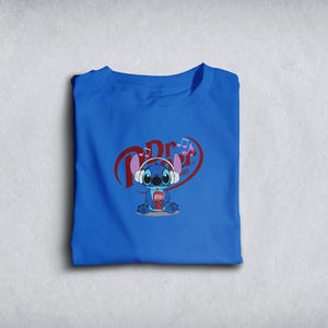 Może przedstawiać: Złożona kr&oacute;lewska niebieska koszulka z postacią z kresk&oacute;wki w słuchawkach i trzymającą nap&oacute;j. Grafika zawiera tekst "Dr. Pepper" w kształcie serca z nutami.