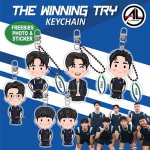 May include: Keychains featuring cartoon illustrations of male figures in various poses, some wearing athletic uniforms. The keychains are attached to metal clasps and black beaded chains. The text "THE WINNING TRY KEYCHAIN" is at the top of the image.