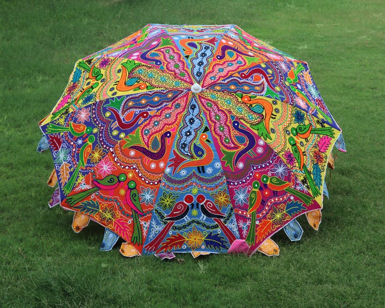 Pode incluir: Um guarda-chuva colorido, costurado &agrave; m&atilde;o, com um design vibrante de flores e p&aacute;ssaros. O guarda-chuva &eacute; feito de tecido e tem uma pega de madeira.