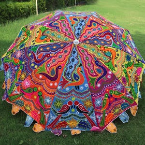 Pode incluir: Um guarda-chuva colorido pintado &agrave; m&atilde;o com um design vibrante de flores e p&aacute;ssaros. O guarda-chuva &eacute; feito de tecido e tem uma pega de madeira.