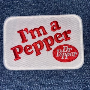 May include: White rectangular patch with rounded corners. The patch features the text "I'm a Pepper" in red, stylized lettering. Below the text is a red oval with the words "Dr Pepper" in white.