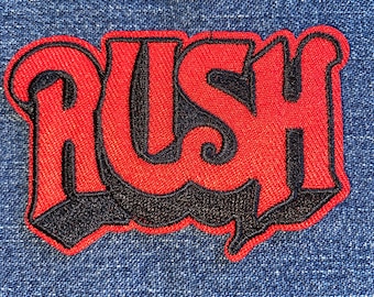 May include: Red and black embroidered patch with the word "RUSH" in a stylized font.