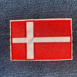 May include: A white ceramic mug with a black handle and the text "But First, Coffee" in a bold, black font. The mug is set against a neutral background, highlighting its simple design.