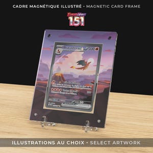 Puede incluir: Un marco magnético transparente que muestra una carta de Pokémon con una ilustración de Charizard. El marco tiene un fondo morado y naranja y está sostenido por soportes de acrílico transparente. El texto en la parte superior dice "MARCO MAGNÉTICO ILUSTRADO".