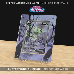 May include: A clear magnetic card frame with a Pokemon card inside. The card features a green and white creature with the name "Celebi" and the number "190". The frame has a black border and is supported by clear plastic stands. The text "MAGNETIC CARD FRAME" is at the top.