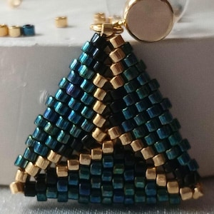 Pu&ograve; includere: Un orecchino triangolare realizzato con piccole perline iridescenti color ottanio, blu scuro e oro metallizzato. La lavorazione geometrica a perline &egrave; fissata a un perno circolare color oro con un inserto centrale liscio rosa pallido.