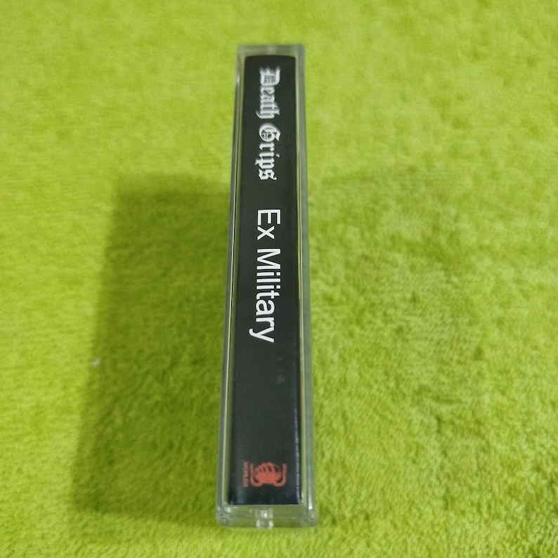 May include: A black cassette tape with the text "Death Grips Ex Military" printed on the label.