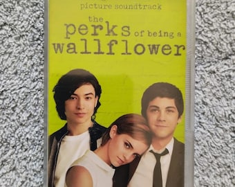 May include: A cassette tape with a yellow background and the text "original motion picture soundtrack the perks of being a wallflower" in black. The image features three people, two men and one woman, looking at the camera.