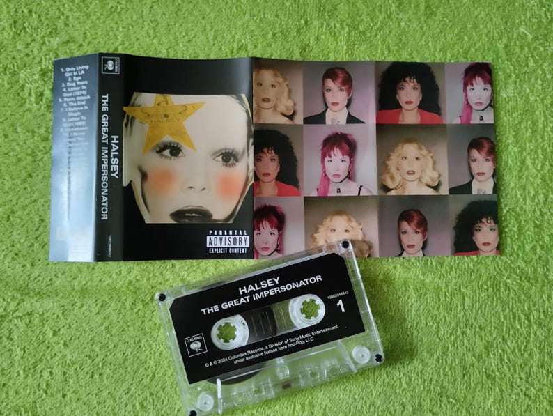 May include: A cassette tape and album art for Halsey's "The Great Impersonator." The cassette tape is clear with black text. The album art features a close-up of a face with a yellow star and multiple images of the artist.