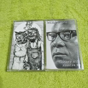 以下が含まれることがあります： 2つのカセットテープ。1つは、2人の漫画のキャラクターの白黒のイラストと「billy woods」というテキストが書かれており、もう1つは、人物の白黒写真と「History Will Absolve Me」というテキストが書かれています。