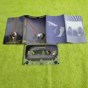 May include: A clear cassette tape labelled "Currents" with a matching album insert. The insert features a black and white striped design with a surreal image of a sphere and a red line. The cassette is on a green surface.