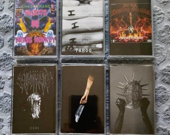 May include: Six cassette tapes with different album covers. The covers feature black and white images, a hand holding a knife, a skull with spikes, and a person with long hair. The text on the tapes includes "GHOSTMANE", "TABOO", "For The Aspiring Occultist", and "REBORN".