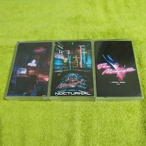 May include: Three cassette tapes with colorful artwork. The first tape has the word "Monsters" on it. The second tape has the word "Nocturnal" on it. The third tape has the words "The Midnight" on it.