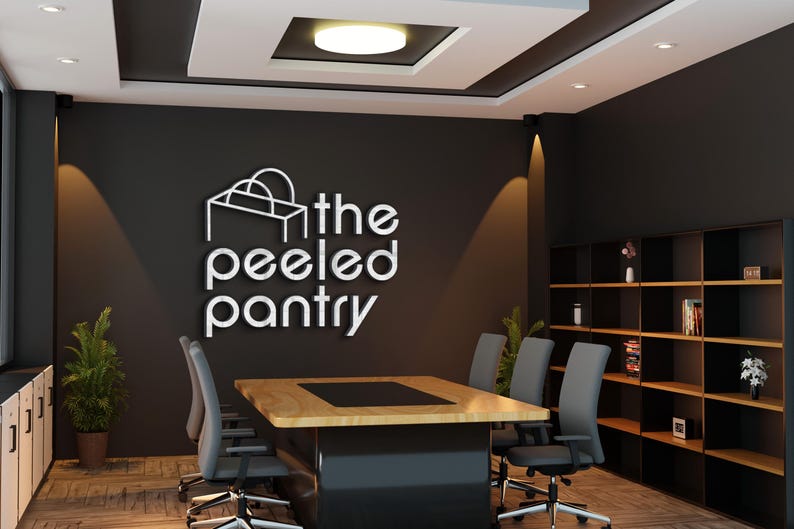 May include: An office interior featuring a conference table, chairs, and a bookshelf. The wall displays the logo "the peeled pantry" in white lettering. The room has a modern design with neutral colors and recessed lighting.