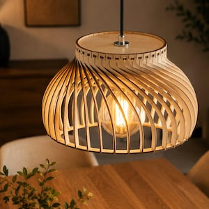 May include: A pendant light fixture featuring a light-colored wooden shade constructed from thin, curved slats arranged in a circular, cage-like pattern. A single clear glass light bulb with a visible filament hangs in the center of the structure.