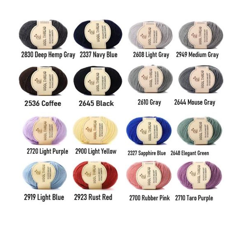 K&ouml;nnte beinhalten: Eine Sammlung von sechzehn Garnkn&auml;ueln in verschiedenen Farben, jedes mit einem beigen Papieretikett mit der Aufschrift WOOL THREAD. Die Farben umfassen Deep Hemp Gray, Navy Blue, Light Gray, Medium Gray, Coffee, Black, Gray, Mouse Gray, Light Purple, Light Yellow, Sapphire Blue, Elegant Green, Light Blue, Rust Red, Rubber Pink und Taro Purple.