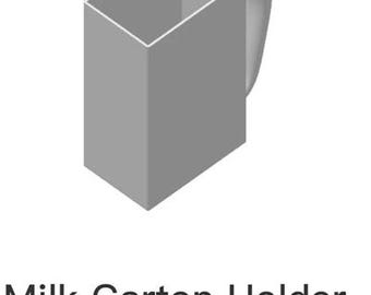 Puede incluir: Un soporte para cartón de leche de plástico gris con asa. El soporte está diseñado para contener un cartón de leche de tamaño estándar. El texto "Milk Carton Holder v2_plate_1.3mf" está impreso en la parte inferior de la imagen.