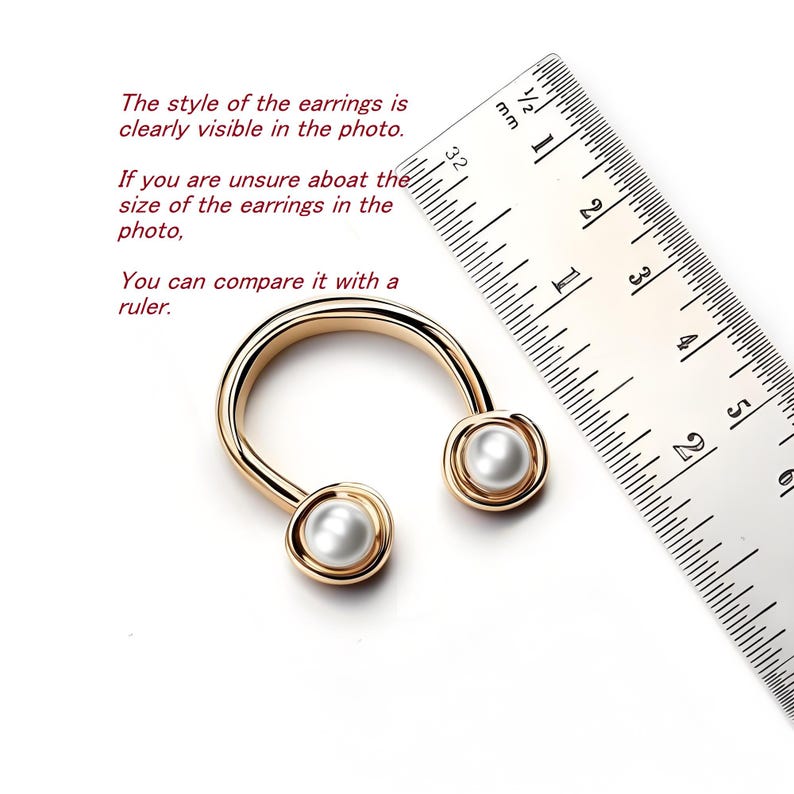 May include: Gold-toned, U-shaped earrings with a pearl at each end. A ruler is next to the earrings, with text that reads, "The style of the earrings is clearly visible in the photo. If you are unsure about the size of the earrings in the photo, you can compare it with a ruler."