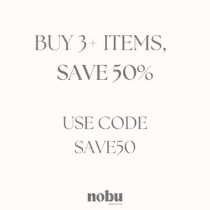 May include: A white graphic sign featuring dark grey text that reads BUY 3+ ITEMS, SAVE 50% followed by USE CODE SAVE50. At the bottom, the text nobu DESIGN STUDIO is displayed in a smaller, bold, dark grey font against the plain white background.