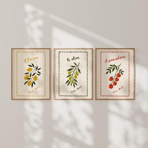 Könnte beinhalten: Drei gerahmte Wandbilder mit botanischen Illustrationen von Zitronen, Oliven und Tomaten. Jeder Druck hat einen dekorativen Rand, den italienischen Namen der Frucht und eine italienische Region in einfacher Handschrift.