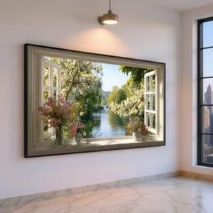 Könnte beinhalten: Ein gerahmtes Wandkunstwerk, das ein offenes Fenster mit Blick auf eine ruhige Flussszene zeigt. Der Fensterrahmen ist hellbeige, mit offenen weißen Fensterscheiben. Vasen mit rosa und weißen Blumen stehen auf der Fensterbank. Das Kunstwerk ist an einer weißen Wand befestigt.