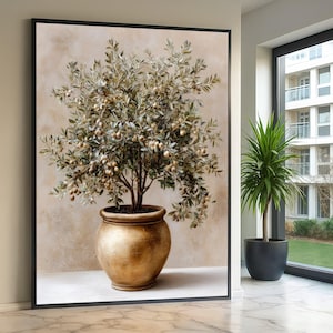 Peut inclure: Une impression d'art mural encadrée représentant un olivier avec de petites olives vertes et brunes dans un grand pot rond en or métallique. L'arbre possède de nombreuses branches fines aux feuilles vert argenté sur un fond beige texturé.