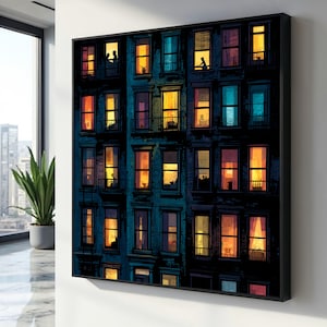 Op de afbeelding: Een ingelijste kunstdruk die een gebouw met meerdere verdiepingen 's nachts afbeeldt. De ramen lichten op met warm licht, wat contrasteert met de donkerblauwe gevel. Silhouetten van mensen zijn zichtbaar in sommige ramen, wat een gevoel van stadsleven creëert.