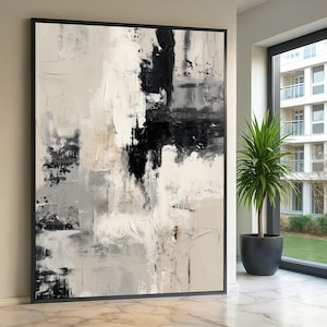 Puede incluir: Obra de arte abstracta enmarcada en negro. La obra presenta un diseño texturizado y en capas con una paleta de negro, blanco y gris. La composición tiene una estética moderna, adecuada para la decoración del hogar o la oficina.