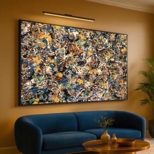 Könnte beinhalten: Abstraktes Gemälde in einem schwarzen Rahmen mit Farbspritzern in Gelb, Blau, Weiß und Braun. Vor dem Kunstwerk befinden sich ein modernes blaues Sofa und ein runder Couchtisch mit Vasen. Warme Atmosphäre.