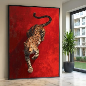 Puede incluir: Una impresión artística en lienzo enmarcada que presenta una pintura detallada de un leopardo sobre un fondo rojo vibrante. El leopardo se representa en una pose de acecho, con su pelaje manchado y su mirada intensa. La obra de arte está enmarcada en un borde negro.