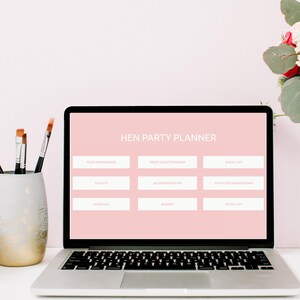May include: A laptop computer with a pink screen displaying a "Hen Party Planner" checklist. The checklist includes categories such as "Guest List", "Flights", "Accommodation", and "To Do List".