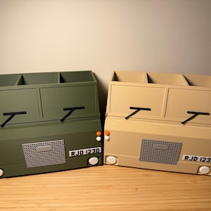 May include: Two desk organizers shaped like the back of a vintage truck. One is green and the other is tan. Both have three compartments and the license plate reads "RJD 123D".