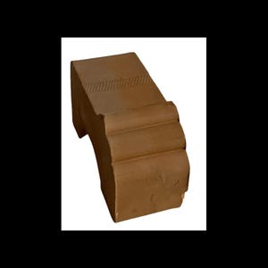 Könnte beinhalten: Eine terracottafarbene keramische Architekturform mit einer gewölbten Oberseite und einem dekorativen Rillenmuster. Die Form hat eine strukturierte Oberfläche und ein leicht verblasstes Aussehen.