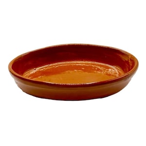 Puede incluir: Un plato para hornear ovalado de terracota con un interior esmaltado. El plato está hecho de barro cocido y tiene un aspecto rústico y hecho a mano.