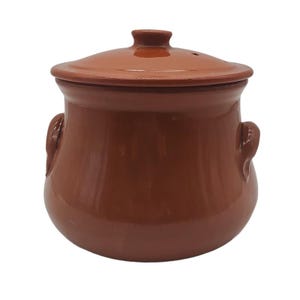 Puede incluir: Una olla de cerámica marrón con tapa y dos asas laterales. La olla tiene forma redondeada y acabado brillante. La tapa tiene un pequeño pomo en la parte superior y un pequeño agujero. La olla se utiliza probablemente para cocinar o almacenar.