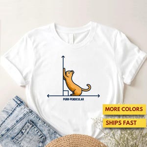 May include: White t-shirt featuring a cartoon cat illustration with the text "PURR-PENDICULAR". The cat is orange and is leaning against a right angle. The shirt also has the text "MORE COLORS" and "SHIPS FAST".
