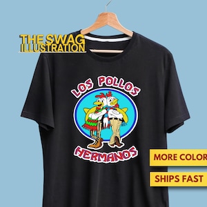 May include: Black t-shirt featuring a cartoon design of two chickens in a blue circle with the words "LOS POLLOS HERMANOS". The shirt also has the text "THE SWAG ILLUSTRATION".