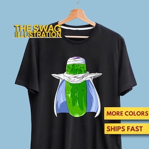 Könnte beinhalten: Schwarzes T-Shirt mit einer Cartoon-Gurkenfigur mit weißem Umhang und Kopftuch. Der Text "THE SWAG ILLUSTRATION" befindet sich über der Grafik. Das Shirt hat auch den Text "MORE COLORS" und "SHIPS FAST".