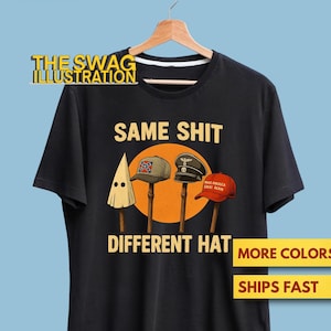May include: Black t-shirt with the text "SAME SHIT DIFFERENT HAT". The shirt features illustrations of a KKK hood, a Confederate hat, a Nazi hat, and a "Make America Great Again" hat. The Swag Illustration logo is at the top.