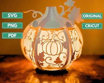 Puede incluir: Una linterna de calabaza de papel blanco iluminada con intrincados recortes de calabazas y hojas. La linterna tiene un tallo y detalles de vid. La imagen incluye el texto "SVG", "PNG", "PDF", "ORIGINAL", "CRICUT" y "THE SWAG ILLUSTRATION".