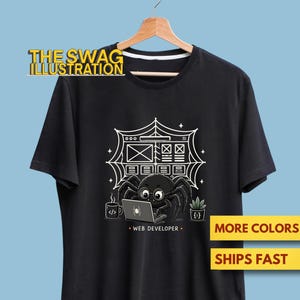 May include: A black short-sleeved t-shirt featuring a graphic of a spider wearing glasses and working on a laptop. The design includes a spider web background, a coffee mug with code symbols, a potted plant, and the text WEB DEVELOPER.