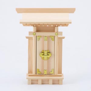 May include: A small wooden shrine with a closed door and gold accents. The shrine is made of light wood and has a traditional Japanese design.
