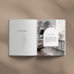 May include: An open book with a white background and black text. The left page has a table of contents with headings like "Our mission", "About us", "Meet the team", and "Buying journey". The right page has a photo of a living room with a wooden table and chairs, and a text box with the heading "Our mission".