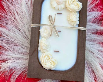Vela con forma de flor en cuenco de madera