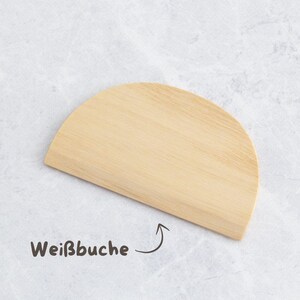 K&ouml;nnte beinhalten: Ein helles, halbkreisf&ouml;rmiges Schneidebrett aus Holz. Das Brett hat eine glatte Oberfl&auml;che und ein nat&uuml;rliches Holzmaserungsmuster. Der Text "Wei&szlig;buche" ist in brauner Schrift mit einem Pfeil auf dem Brett geschrieben.