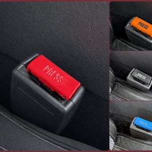May include: Close-up of a car seat belt buckle with a red release button. The word "PRESS" is printed in white on the button. Additional images show buckles with orange, gray, and blue buttons.