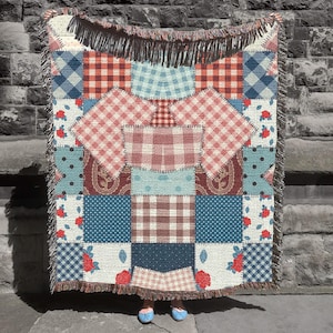May include: A patchwork throw blanket with a variety of patterns, including gingham, polka dots, and floral designs. The blanket features a fringed edge and a mix of red, blue, and cream colours. The blanket is made of a soft material.