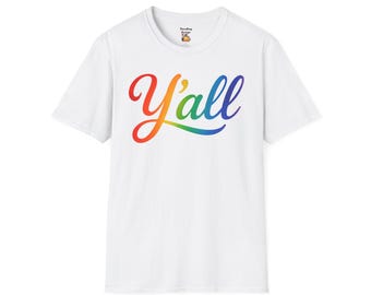 Op de afbeelding: Wit T-shirt met het woord "Y'all" in een regenboogverloop over de voorkant. De tekst is in een cursief lettertype. Het shirt heeft korte mouwen en een ronde hals.